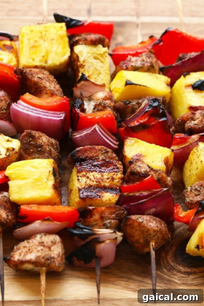 Grilled Pineapple and Jerk Chicken Kebabs arranged on a cutting board after being cooked, showing the beautiful char and vibrant colors.