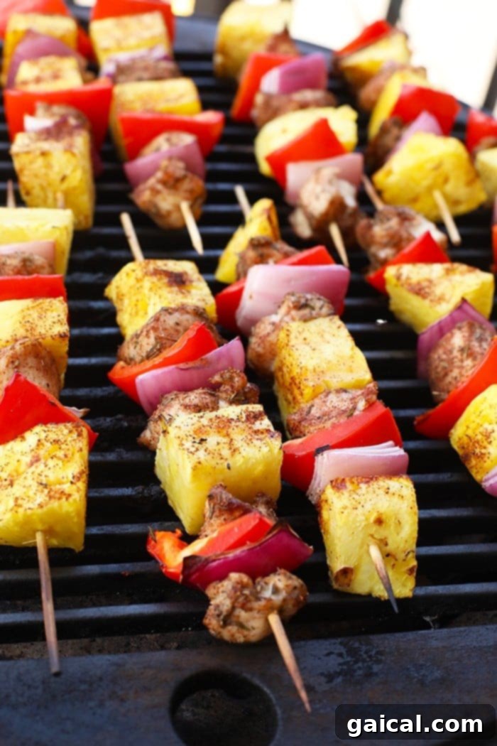 Grilled Pineapple and Jerk Chicken Kebabs sizzling on an outdoor grill, with visible flames and smoke, creating a delicious char.