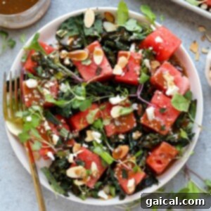 A refreshing watermelon salad with a twist of grilled kale and toasted almonds, beautifully presented for a healthy and flavorful meal.