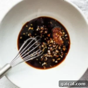 A small white bowl containing a rich, dark stir-fry sauce, ready for use in a recipe.