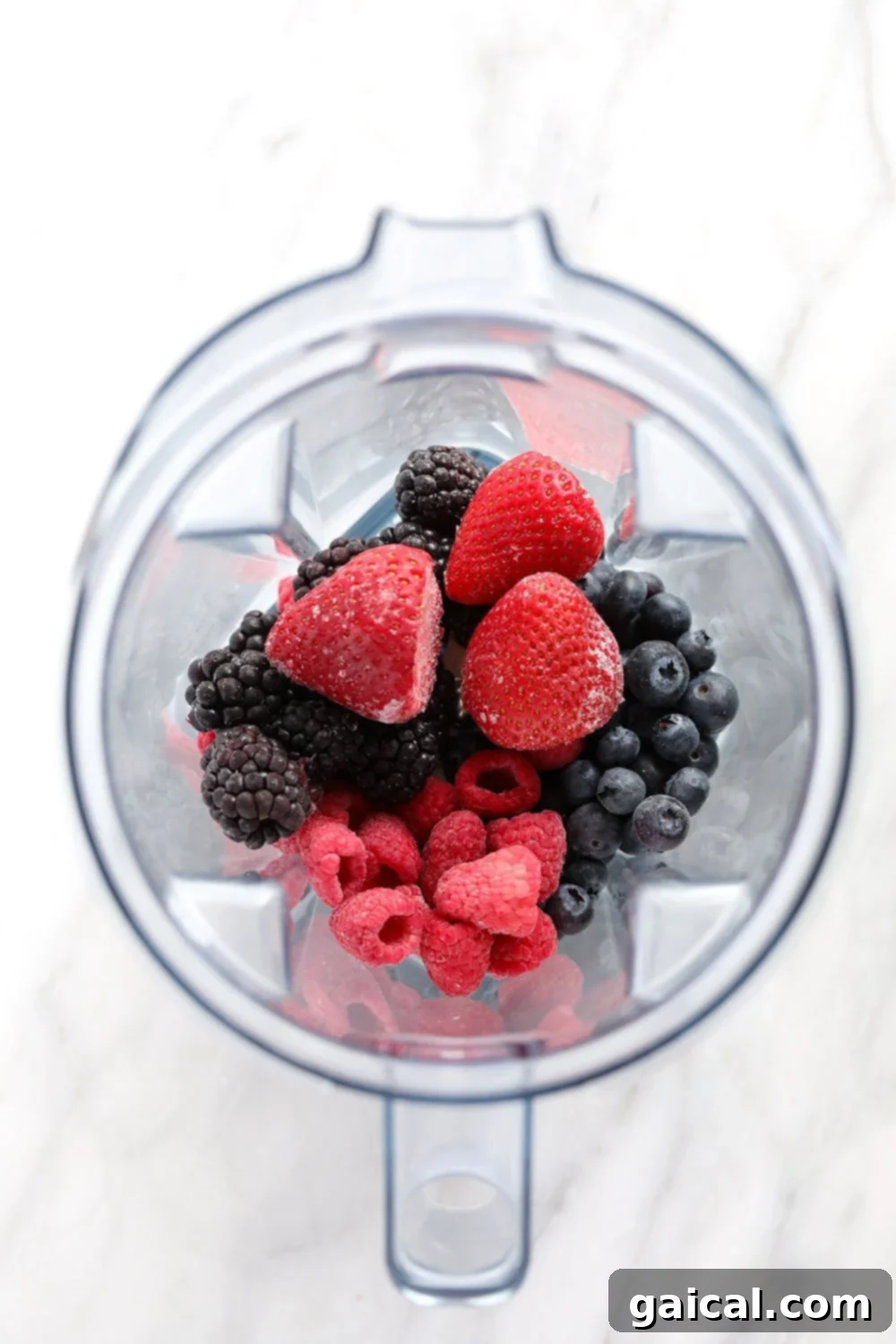 Frozen Berries Ready for Smoothies Blender with various frozen berries and other ingredients, ready to make a smoothie