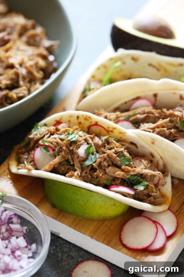 This carnitas recipe (Instant Pot) is absolutely to die for and can be served in so many ways including tacos, nachos, bowls, and more! tacos on cutting board