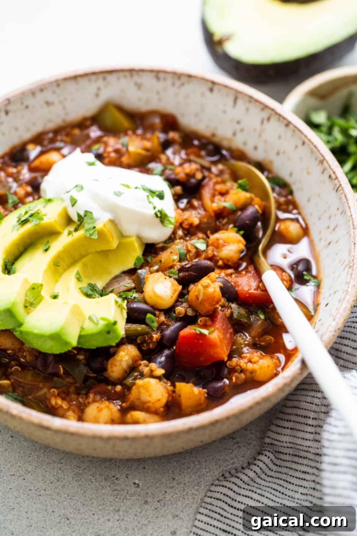 A perfect bowl of black bean quinoa chili. A beautifully presented bowl of black bean quinoa chili, garnished with fresh cilantro and lime wedges, ready to be enjoyed.