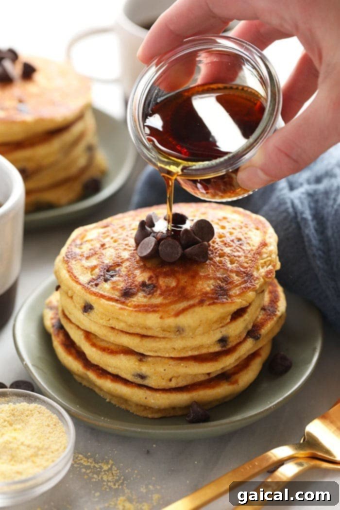 Pancakes drenched in maple syrup, highlighting their fluffy texture and golden-brown edges.