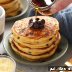 A stack of golden-brown, fluffy gluten-free cornbread pancakes on a plate.
