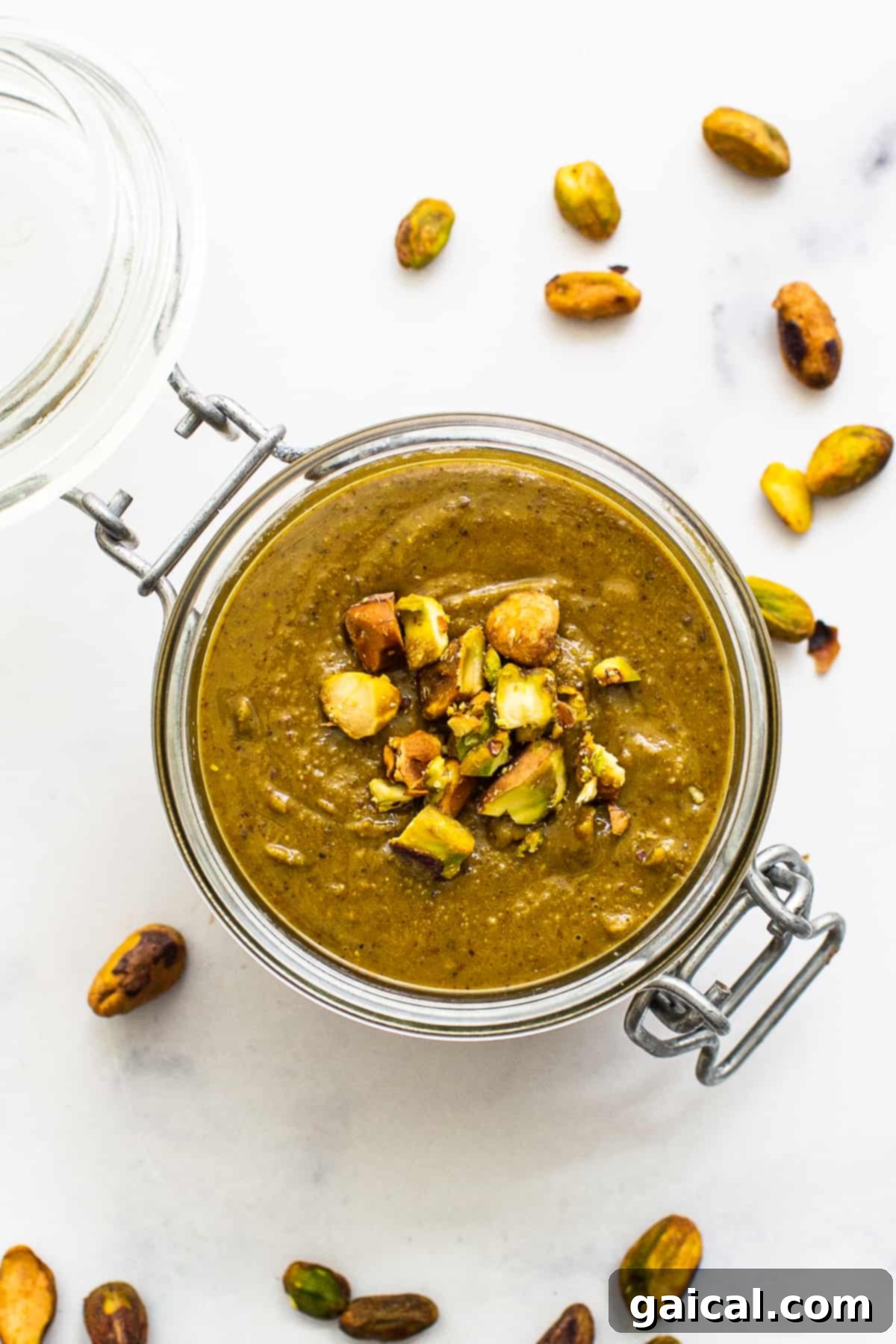 A glass dish filled with creamy homemade maple sea salt pistachio butter, ready to be enjoyed.