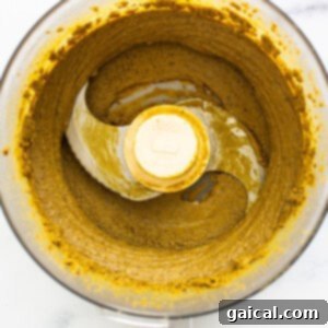 Creamy pistachio butter with maple syrup being mixed in a food processor.