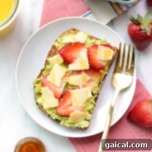 Avocado toast with strawberries and guacamole, topped with cheese and honey.