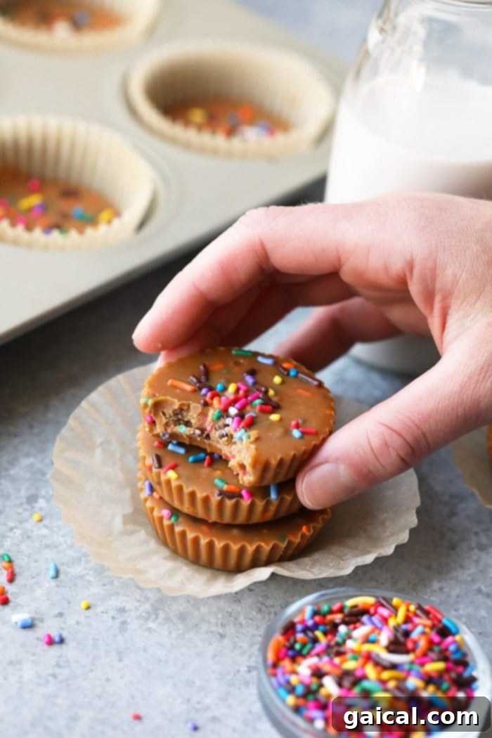 Cashew Butter Cake Batter Bliss Bites 5 A tempting display of finished Cake Batter Cashew Butter Cups, sprinkled with colorful decorations and a pinch of sea salt, perfectly arranged on a plate.
