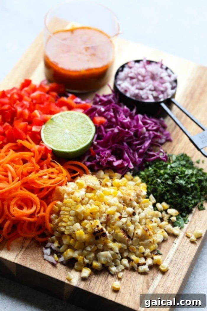 Prepped Ingredients: The Foundation of a Flavorful Thai Corn Salad An organized display of fresh ingredients for Thai Chili Corn Salad on a rustic wooden cutting board: golden grilled corn cobs, vibrant red bell pepper, crisp carrots, thinly sliced red onion, fresh cilantro sprigs, and a dollop of green curry paste.