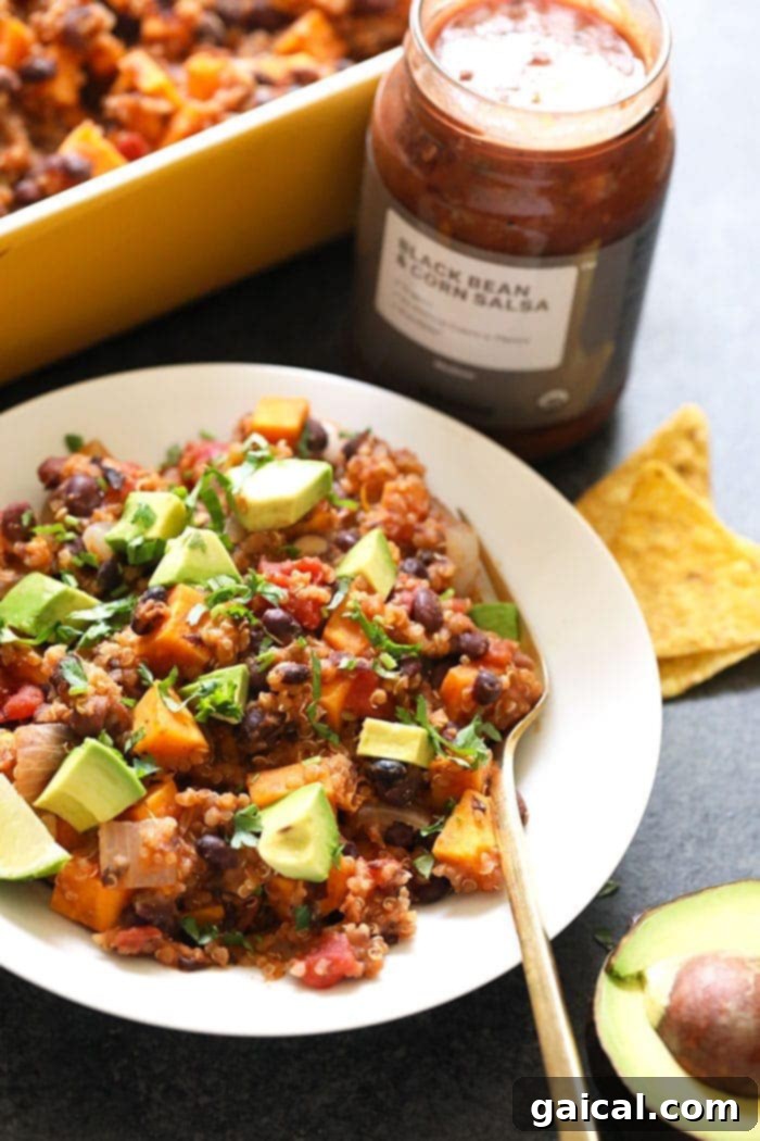 Vegan Mexican Quinoa and Sweet Potato Casserole - Meal Prep Friendly. A delicious Mexican Sweet Potato Quinoa Casserole in a bowl, garnished.