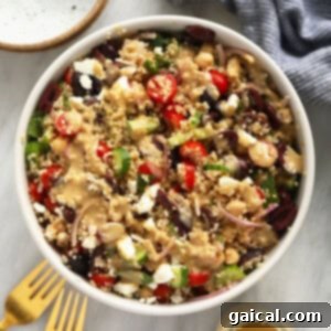 Vibrant Mediterranean Quinoa Bowl 2 quinoa salad recipe in a white bowl with a fork.