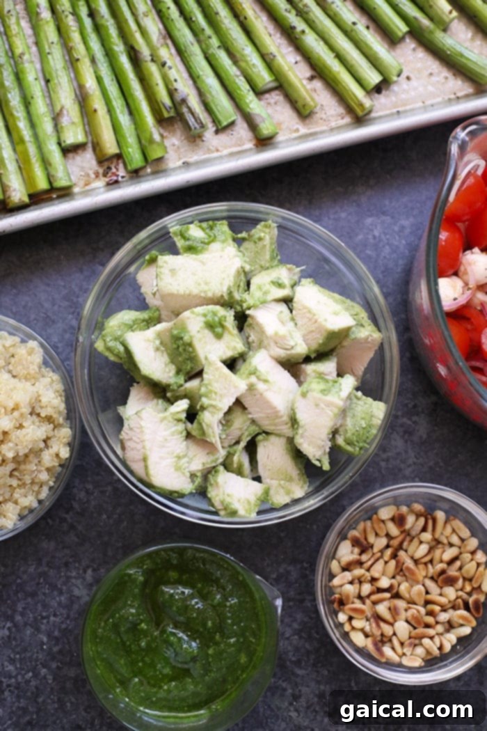 Perfectly cooked pesto chicken breast, sliced into cubes and ready to be combined with roasted asparagus and quinoa in a meal prep bowl.