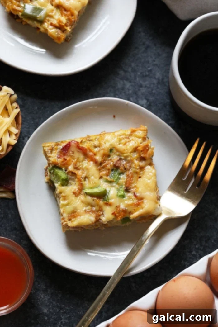 Delicious & Healthy Sweet Potato Hash Breakfast Casserole Slice A perfectly portioned slice of healthy breakfast casserole on a white plate, showcasing layers of sweet potato, eggs, bacon, and cheese.