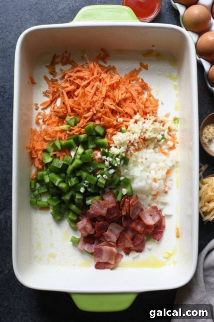 Fresh Ingredients for Healthy Sweet Potato Breakfast Casserole Raw ingredients for a breakfast casserole, including grated sweet potato, chopped vegetables, and bacon in a baking dish, ready to be mixed with eggs.