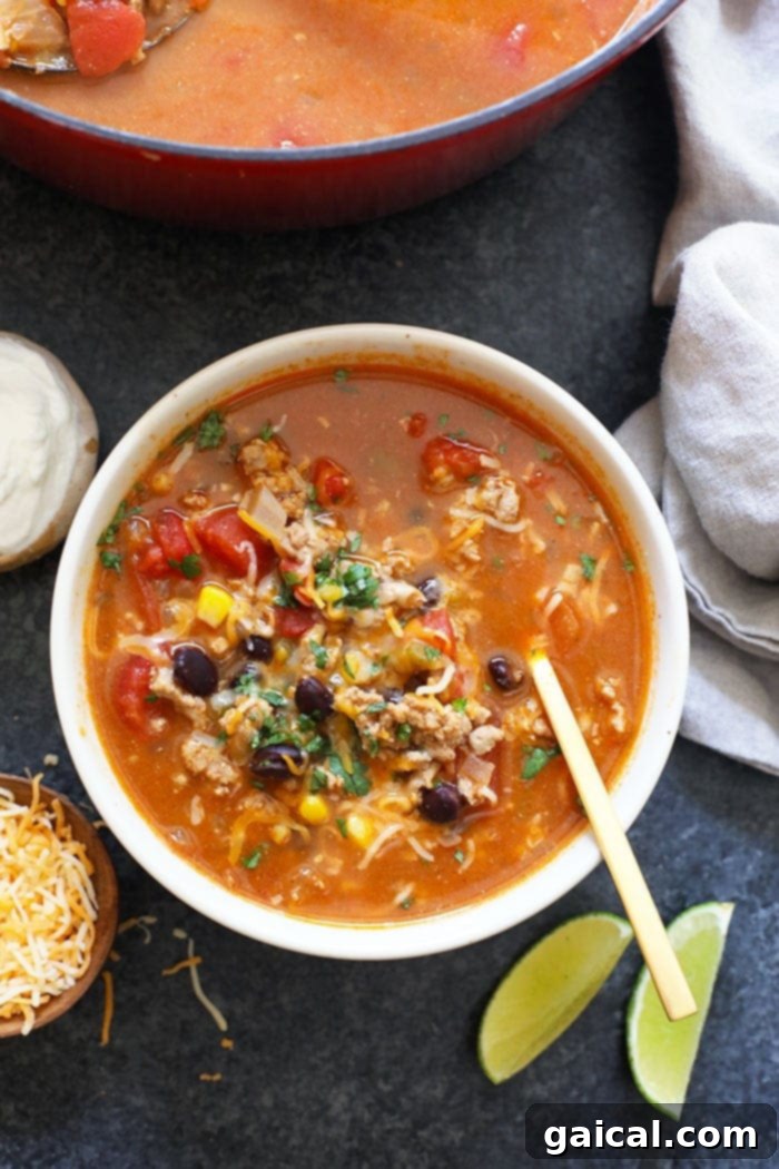 Hearty Taco Bowl 2 A bowl of hearty taco soup topped with fresh cilantro and a dollop of sour cream, ready to be enjoyed with tortilla chips.