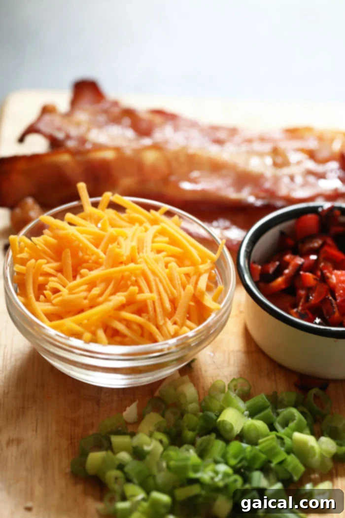 Essential toppings for loaded cauliflower potato soup: crispy bacon, fresh green onions, roasted red peppers, and shredded cheese. A selection of delicious toppings for cauliflower potato soup, including bacon bits, chopped green onions, roasted red peppers, and shredded cheddar cheese, arranged in small bowls.