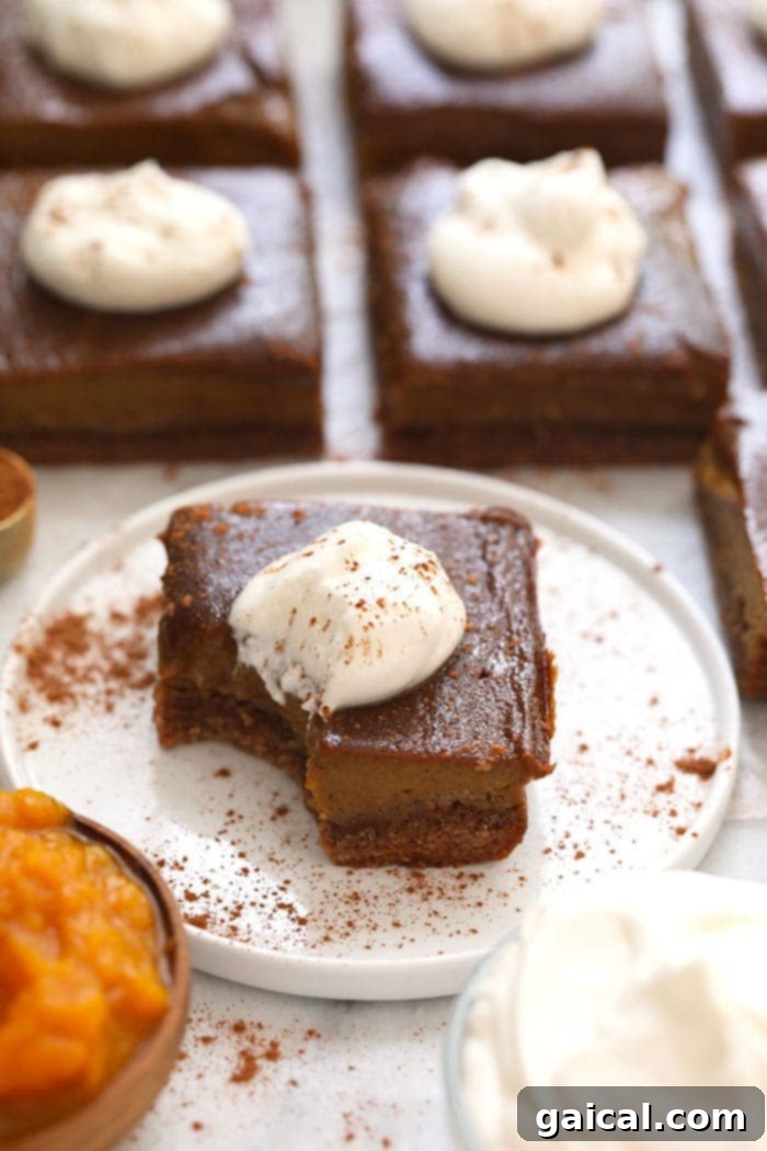 Wholesome Pumpkin Spice Bars 2 A perfectly portioned healthy pumpkin pie bar on a white plate, ready to be enjoyed.