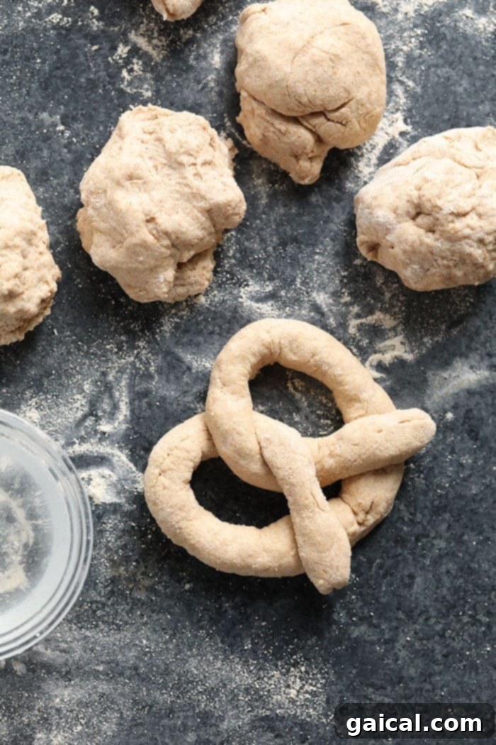 Guilt-Free Homemade Soft Pretzel Recipe 7 A hand demonstrating how to twist a dough rope into a classic pretzel shape.