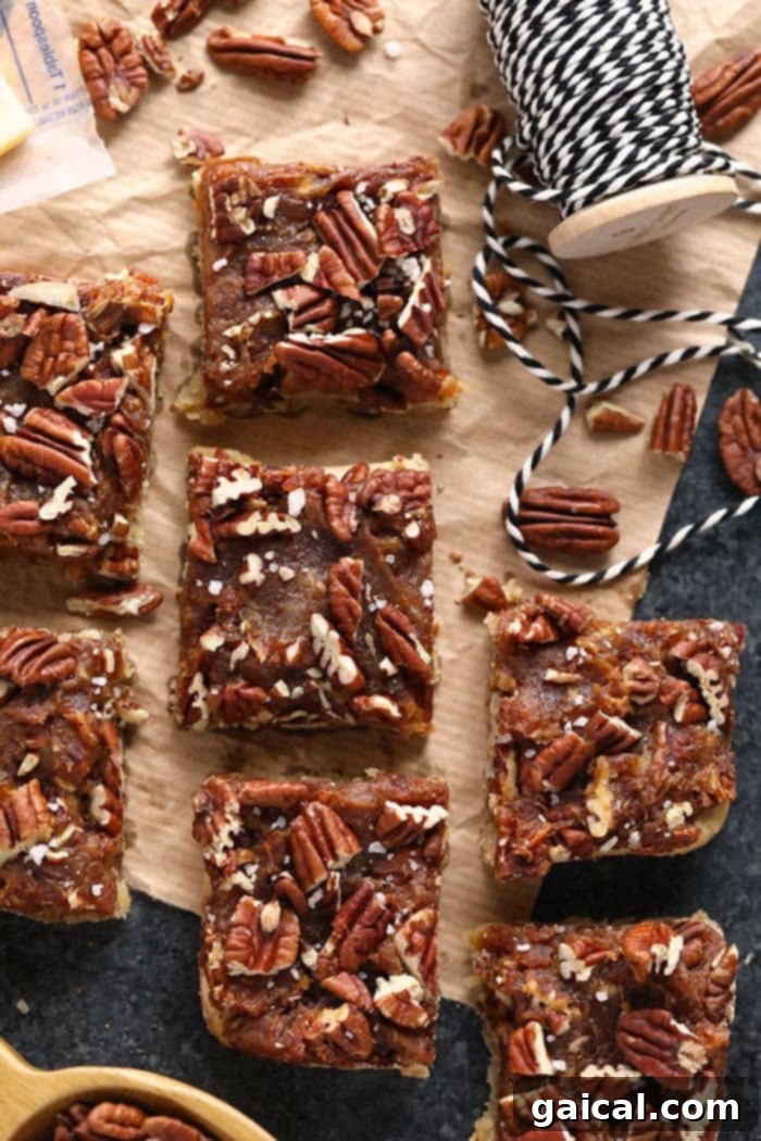 Freshly Baked Pecan Pie Bars A close-up of freshly baked, finished easy pecan pie bars, glistening with date caramel and topped with pecans.