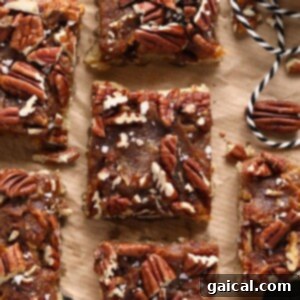 Easy pecan bars on a piece of parchment paper, ready to be cut.