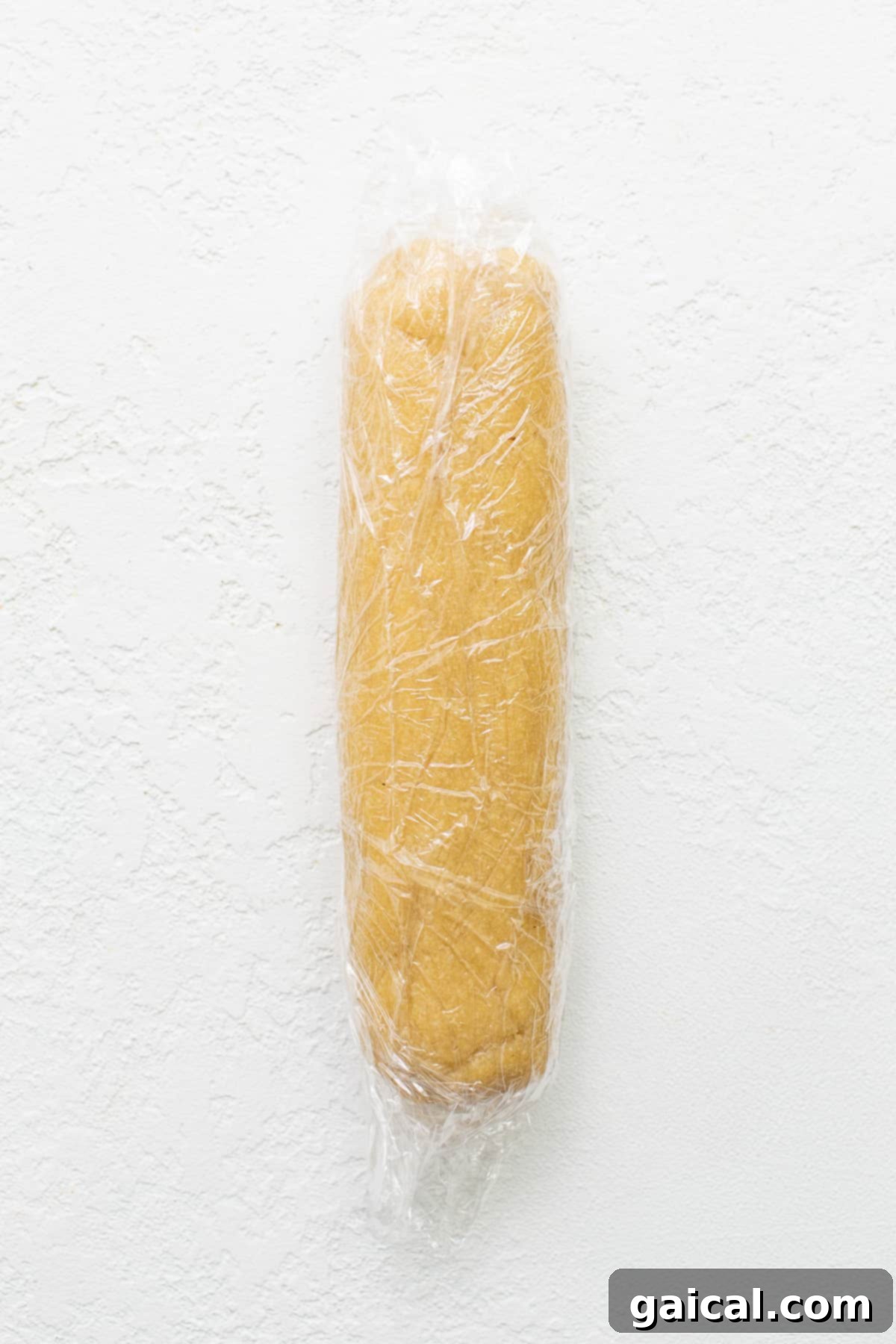 Delicate Almond Flour Shortbread 4 Almond flour cookie dough log wrapped tightly in plastic wrap, chilling in the refrigerator.