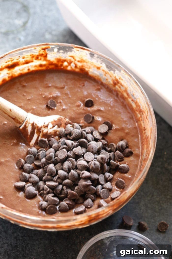 Thick, rich chocolate banana bread batter in a mixing bowl, ready for baking.