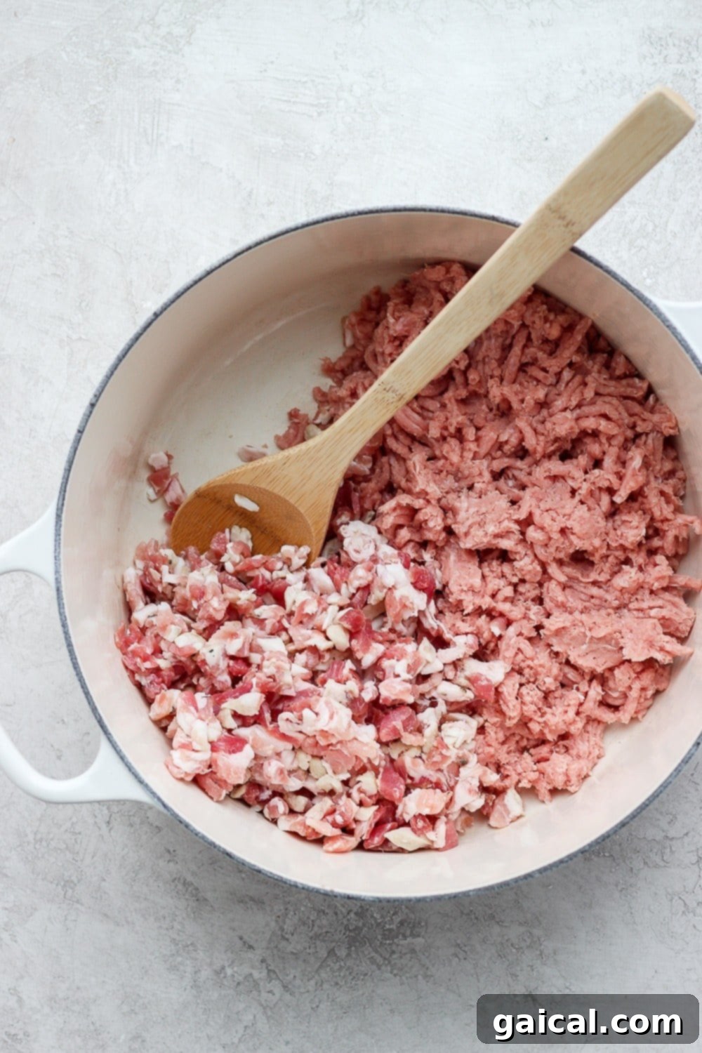 Fresh ingredients for ground turkey farro soup, including kale, mushrooms, pancetta, and farro, neatly arranged in a pot.