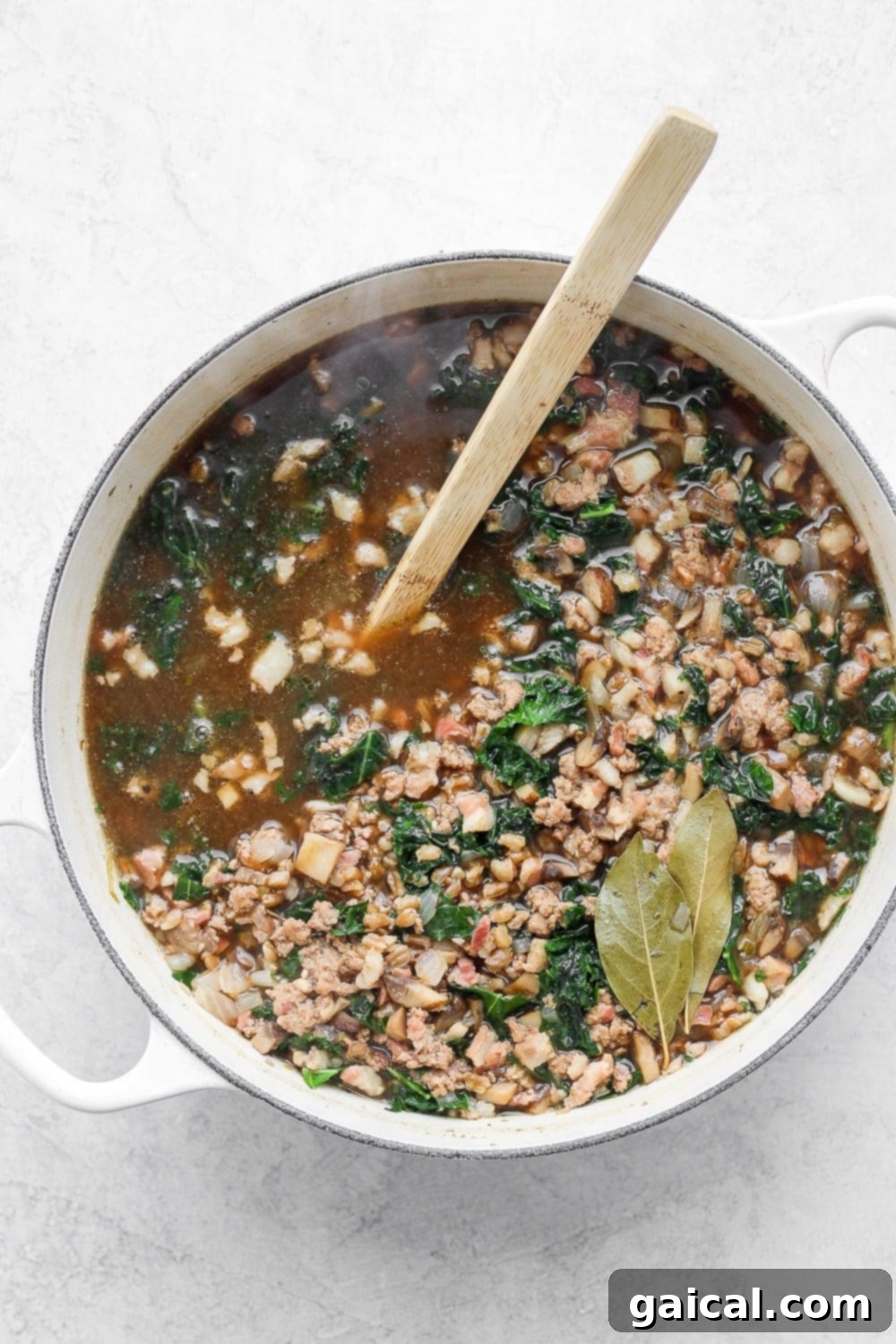A large pot of perfectly simmered ground turkey farro soup with kale, ready to be served.