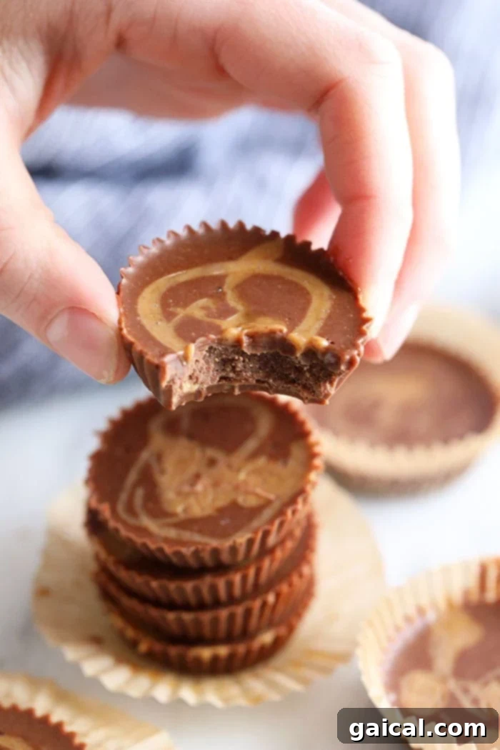 Chocolate Peanut Butter Keto Energy Bites 5 A hand holding a perfectly formed Chocolate Peanut Butter Fat Bomb, ready to eat