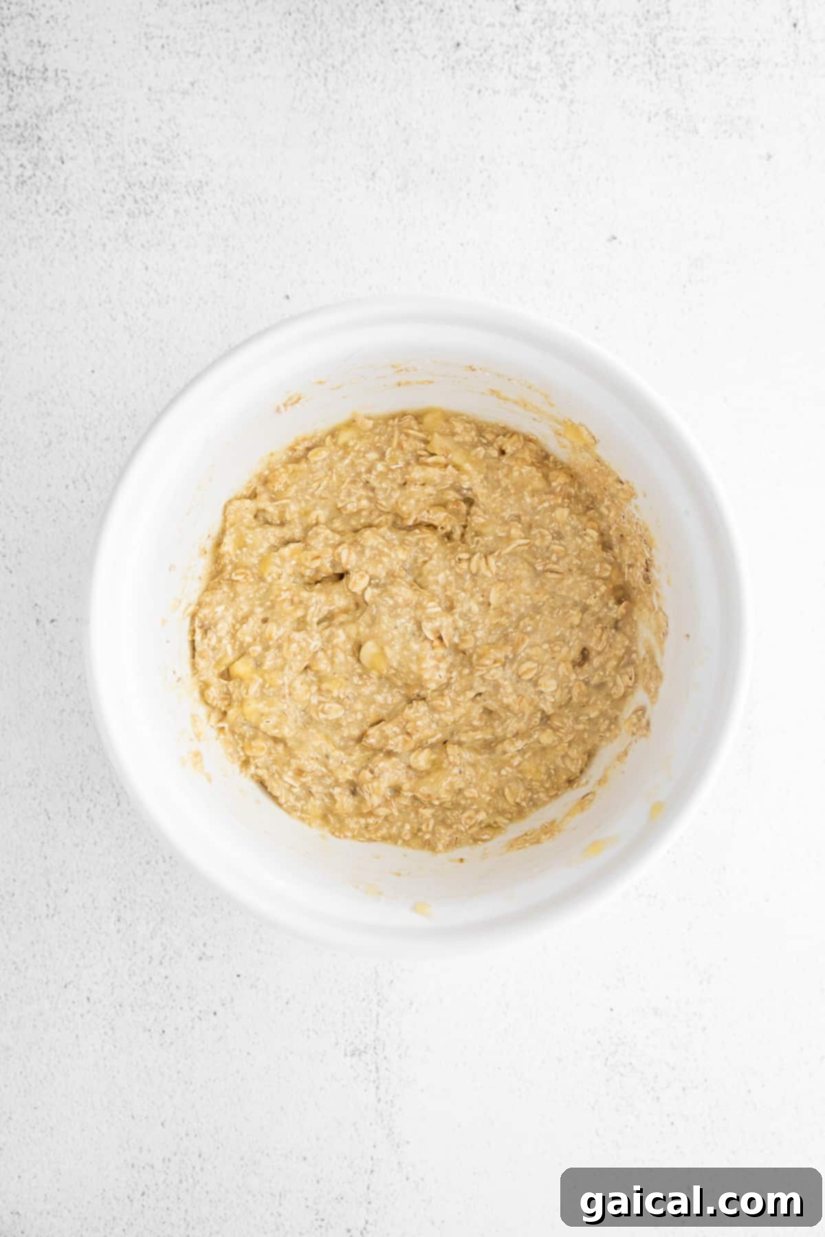 Bowl of freshly prepared banana oatmeal pancake batter, smooth and ready for cooking.