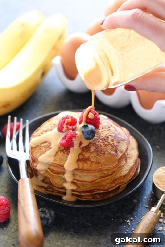 Peanut Flour Protein Powercakes 2 Delicious stack of high-protein peanut flour pancakes drizzled with peanut sauce.