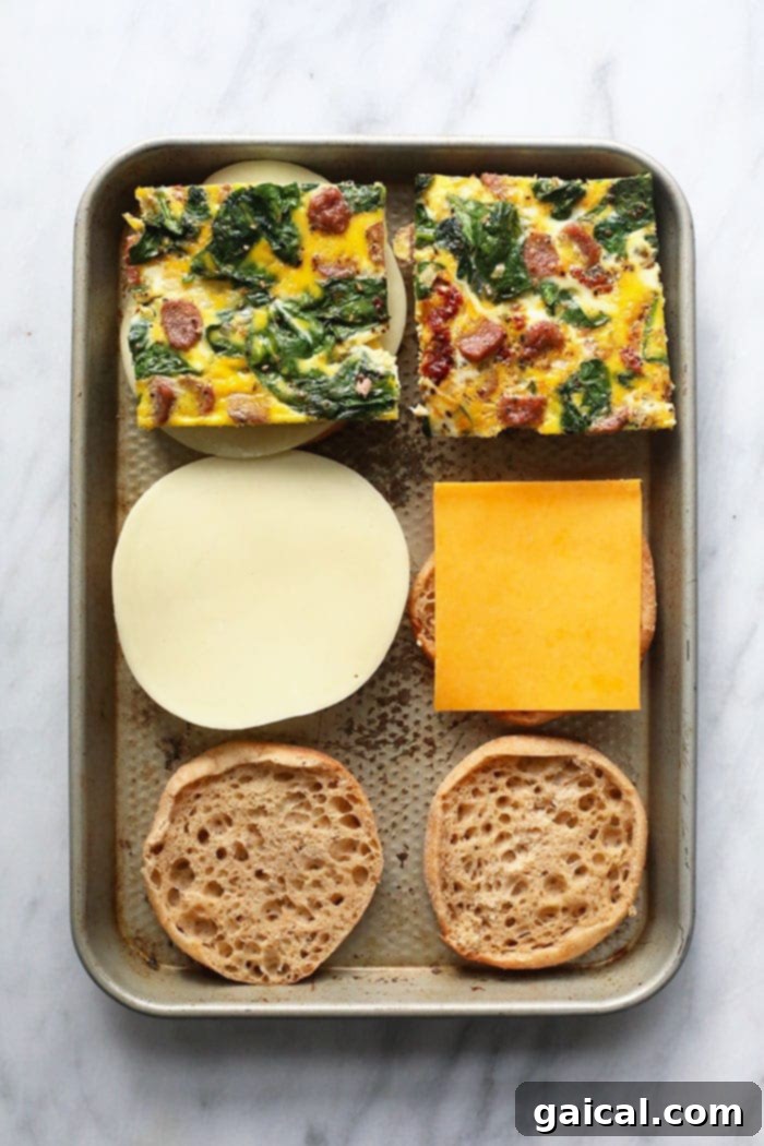 Assembling make-ahead freezer breakfast sandwiches on a baking sheet.