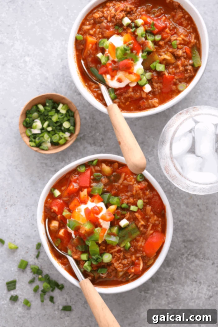 Delicious Instant Pot Stuffed Pepper Soup: A comforting and hearty meal. Two steaming bowls of Instant Pot Stuffed Pepper Soup garnished with fresh herbs and a swirl of cream, showcasing its rich colors and appealing texture, ready to be enjoyed on a cozy evening.
