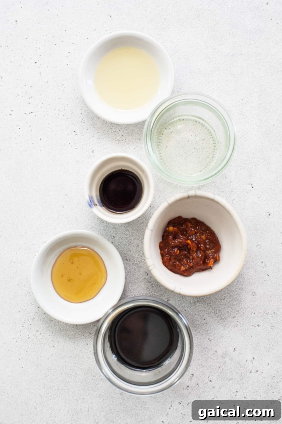 A vibrant selection of fresh and frozen ingredients for Instant Pot fried rice, neatly arranged in bowls on a wooden surface.