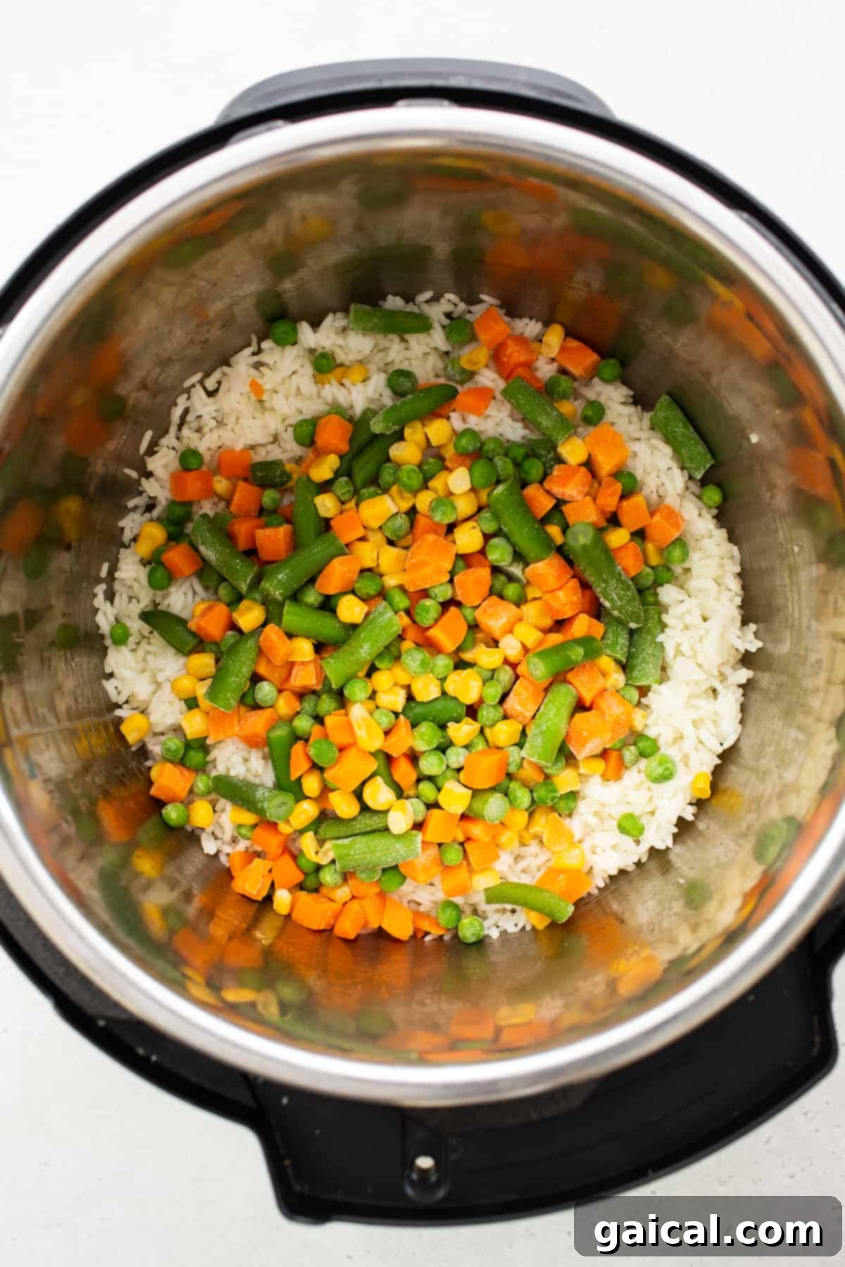 Fried rice being cooked directly inside an Instant Pot, showing the rice, mixed vegetables, and scrambled egg beautifully combined.