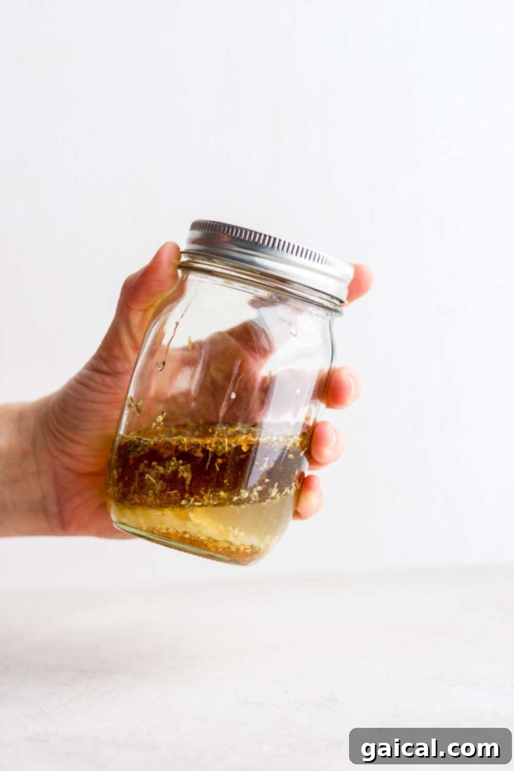 Greek salad dressing A glass jar filled with a fresh, vibrant Greek salad dressing, ready to be enjoyed.