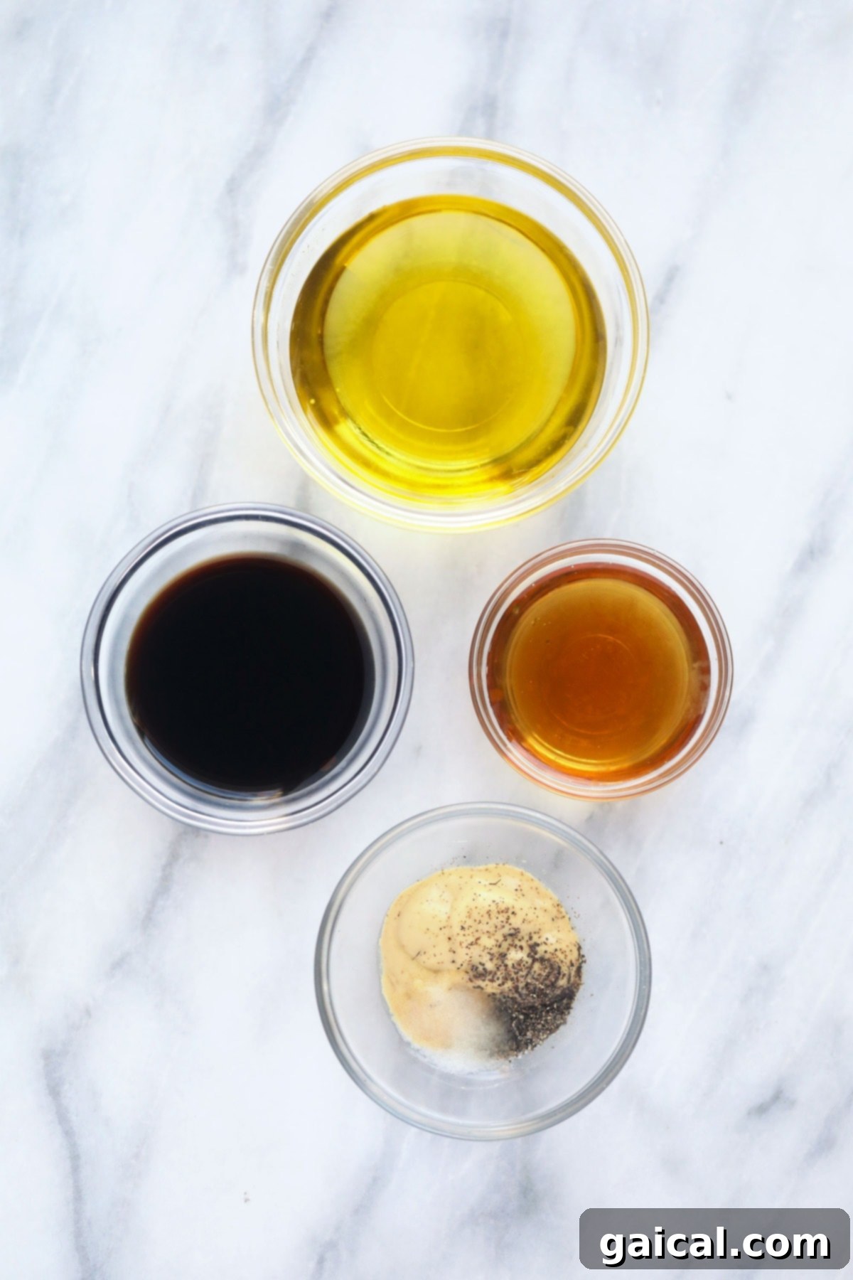Homemade salad dressing ingredients A selection of fresh ingredients commonly used for making salad dressings, including olive oil, various vinegars, lemon, garlic, and fresh herbs.