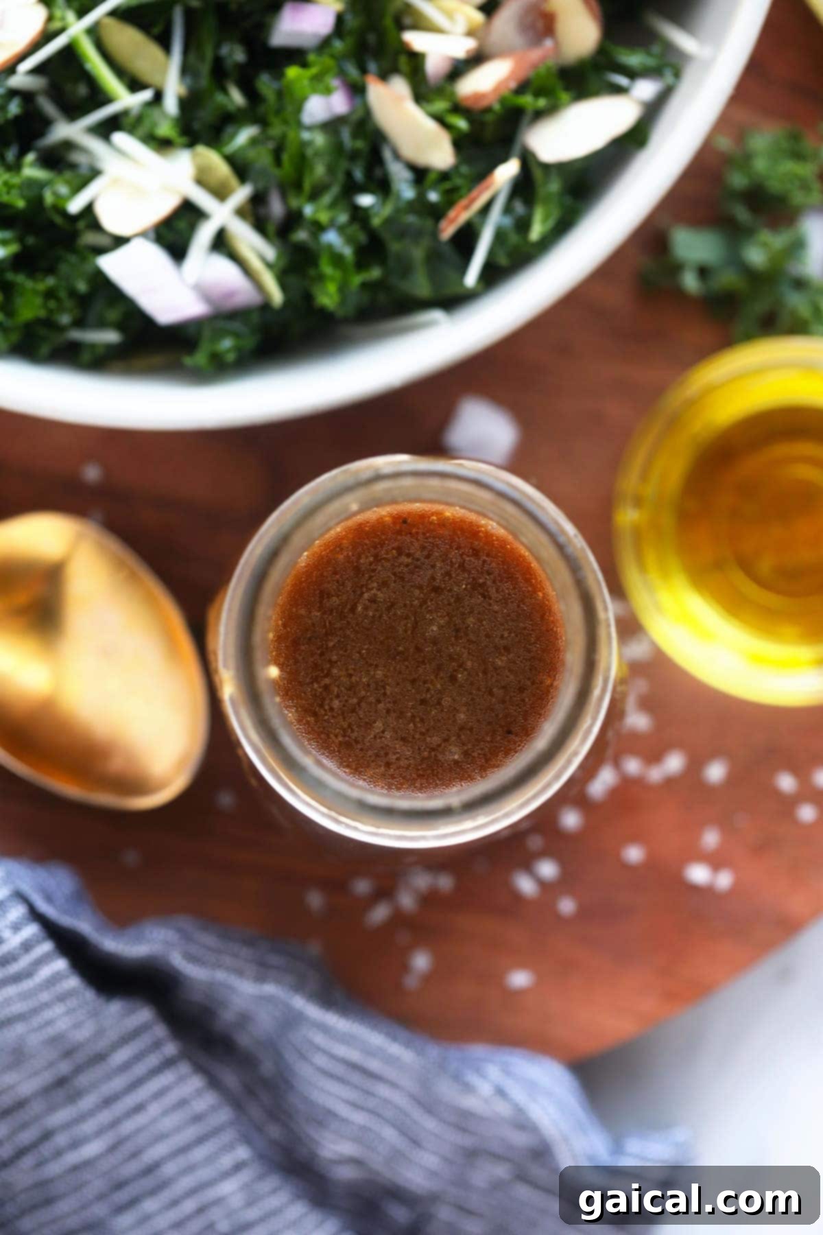 Balsamic Vinaigrette A simple balsamic vinaigrette salad dressing in a glass jar next to a spoon, showcasing its rich color and texture.