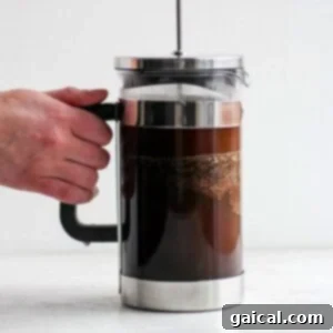 Mastering the French Press 8 A freshly brewed French press coffee pot next to a mug, ready to be served.
