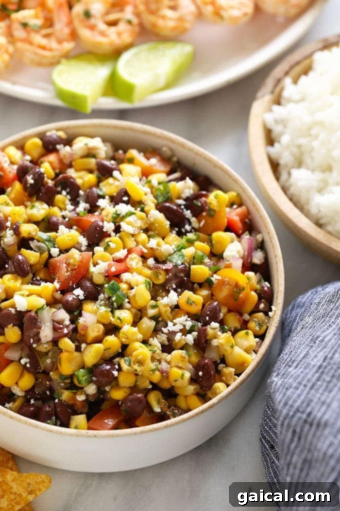 Fresh & Limey Black Bean Corn Salad A close-up shot of black bean corn salad with a fork, emphasizing its fresh ingredients and readiness to eat