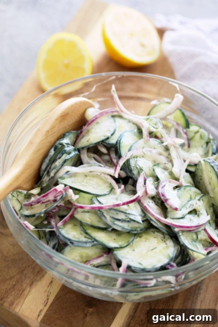 Add this healthy and delicious creamy cucumber salad to your list of must-make recipes! Creamy cucumber salad in a serving bowl, ready to eat.