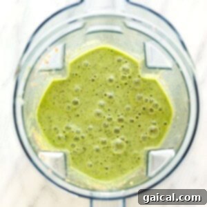 Kale smoothie being blended to a smooth consistency in a high-speed blender.