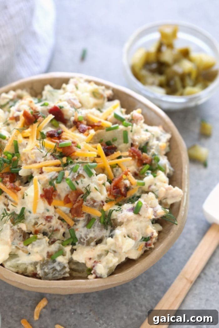 A close-up of loaded baked potato salad in a serving bowl, ready to be enjoyed.