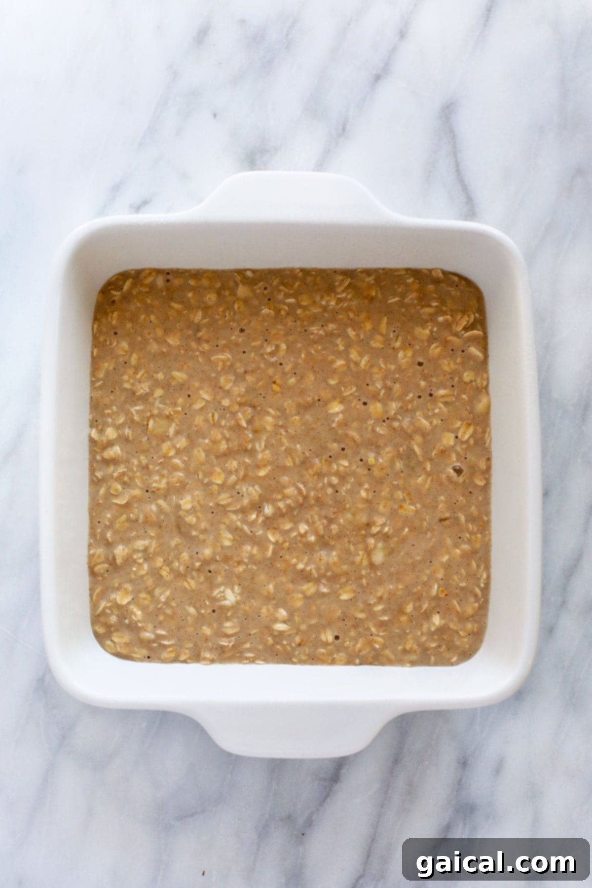 Baked oatmeal in a casserole dish, topped with fresh fruit and nuts, ready to be served.