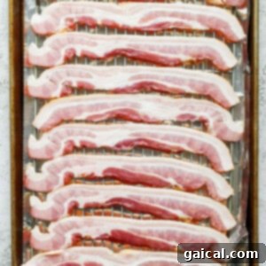 sliced bacon on a baking sheet.