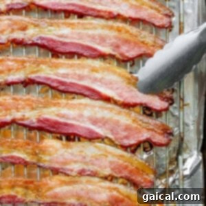 bacon on a baking sheet with a fork.