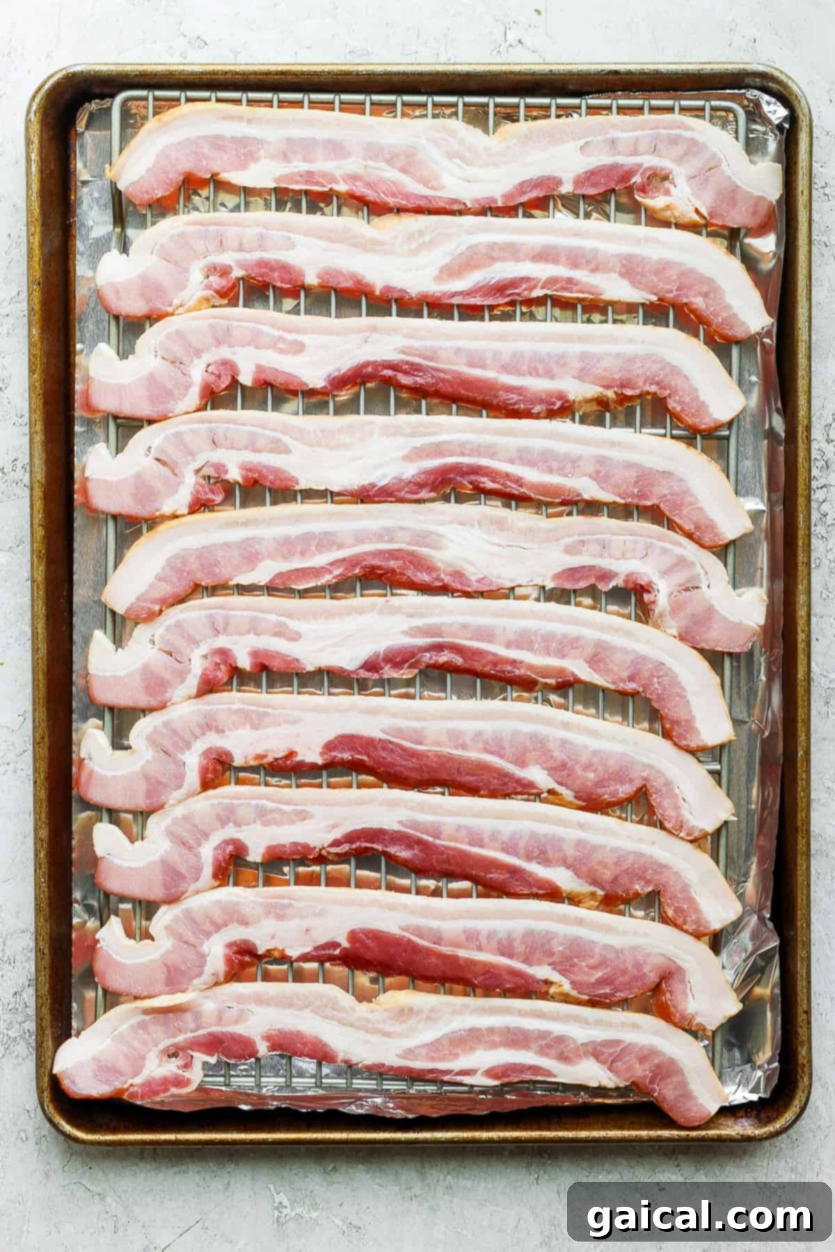 Mastering Crispy Oven Bacon 5 sliced bacon on a baking sheet.
