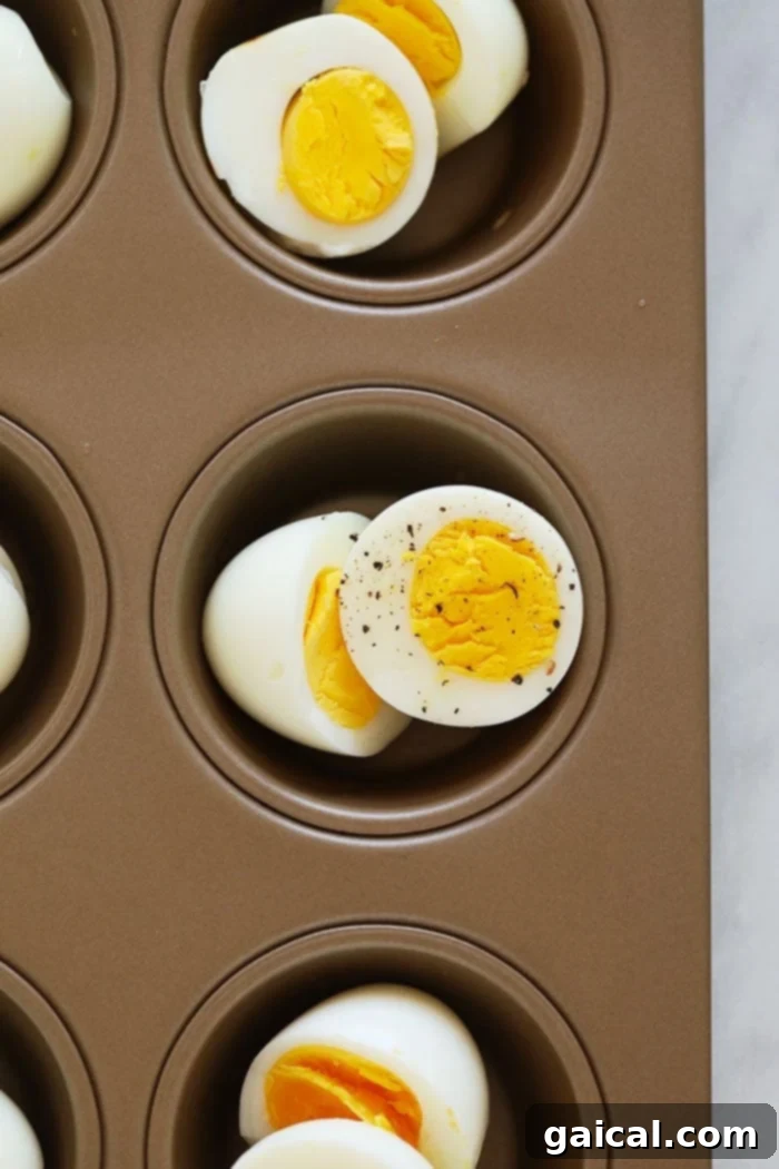 Making hard boiled eggs in the oven AKA Baked Hard Boiled Eggs is a foolproof method for perfect hard boiled eggs every time! Hard-boiled eggs cooling in a muffin tin in the oven