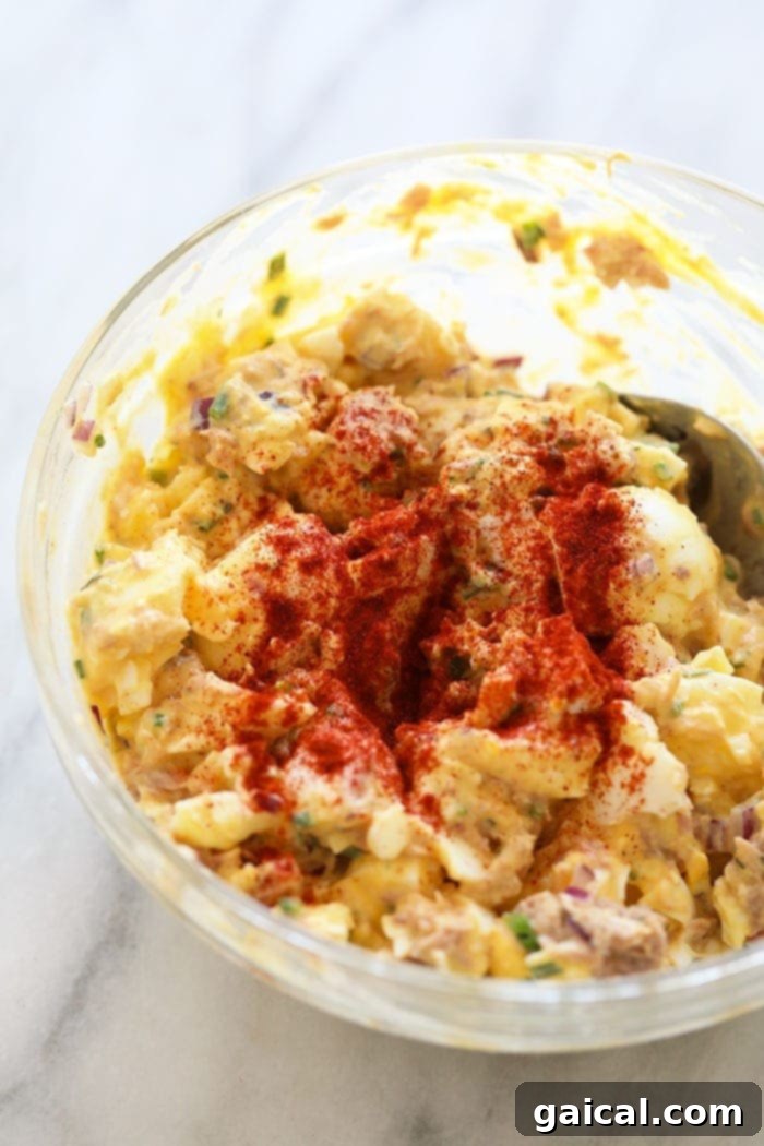 Hearty Tuna Egg Salad 5 Creamy tuna egg salad mixed thoroughly in a bowl, showing the blended textures of tuna, chopped eggs, and herbs.